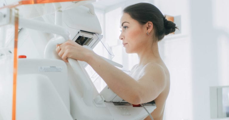 Woman getting her breast scanned in a Mammography machine